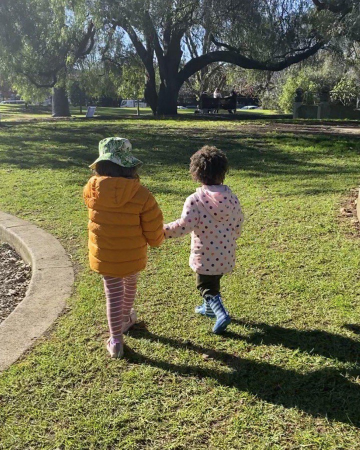 Two children holding hands in a park